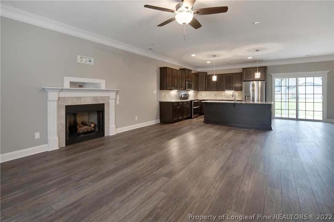 2643 Riddle Farm Hope Mills, NC 28348 - Photo 6 of 50 an open kitchen with kitchen island wooden floor and stainless steel appliances
