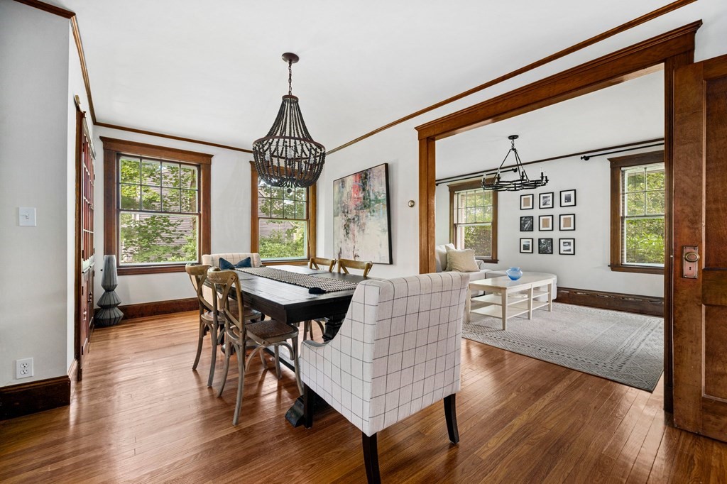 88 Independence Street Canton, MA 02021 - Photo 8 of 30 a dining room with wooden floor a chandelier a wooden table and chairs