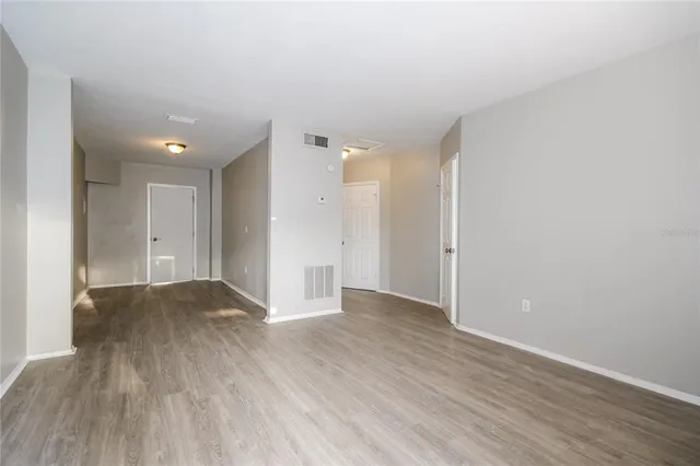 a view of an empty room and wooden floor