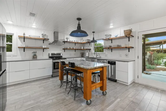a kitchen with stainless steel appliances granite countertop a sink stove and refrigerator