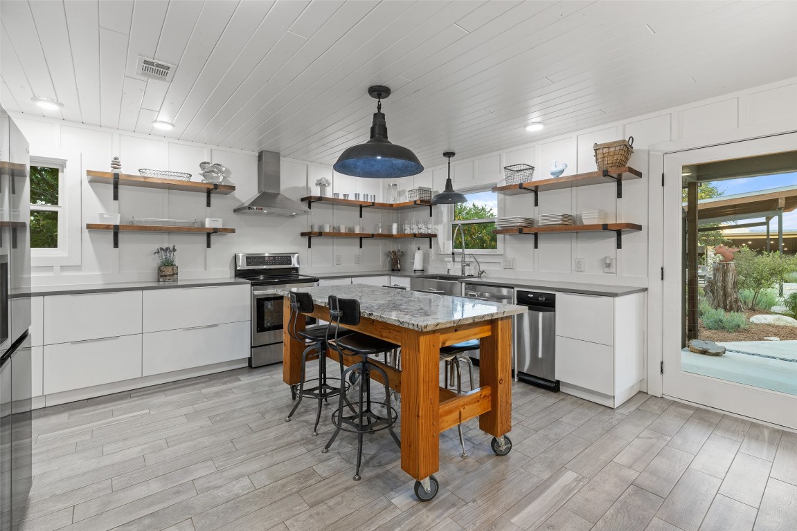 201 Gold Nugget Road Wimberley, TX 78676 - Photo 31 of 40 a kitchen with stainless steel appliances granite countertop a sink stove and refrigerator