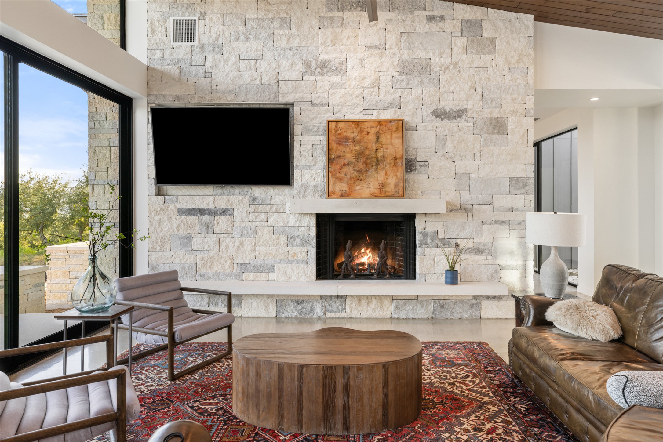 201 Gold Nugget Road Wimberley, TX 78676 - Photo 6 of 40 a living room with furniture a flat screen tv and a fireplace