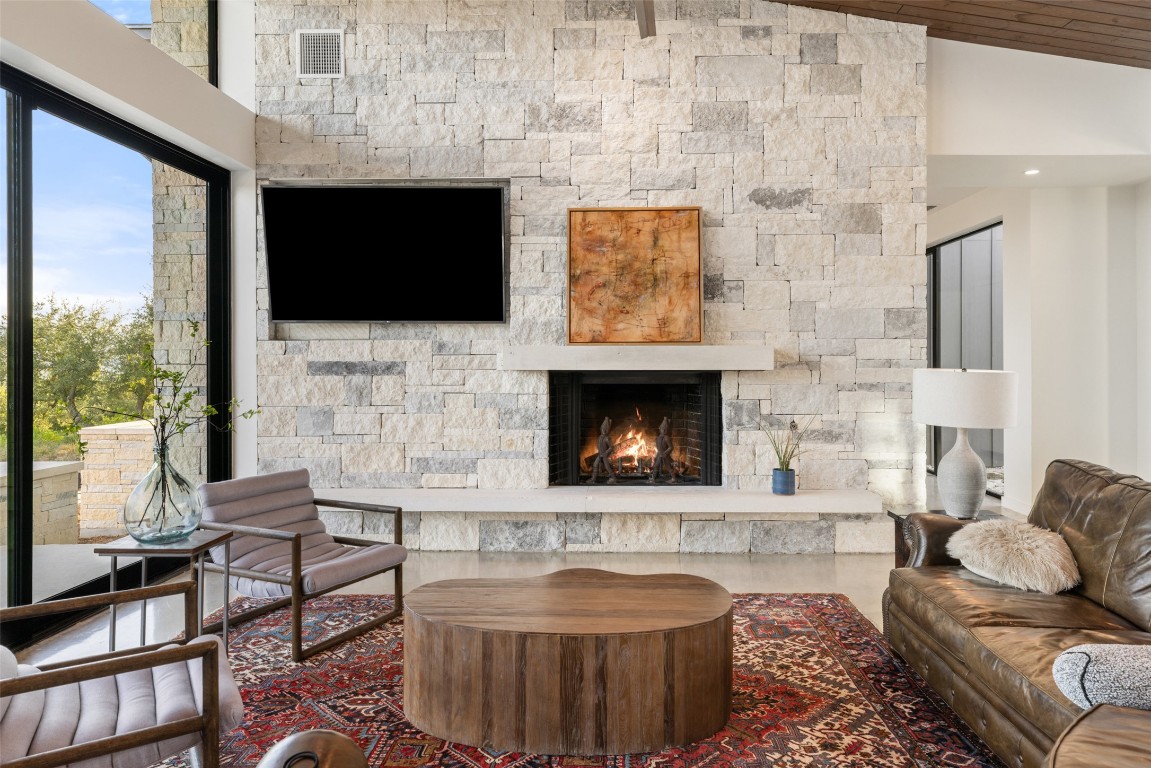 201 Gold Nugget Road Wimberley, TX 78676 - Photo 6 of 40 a living room with furniture a flat screen tv and a fireplace