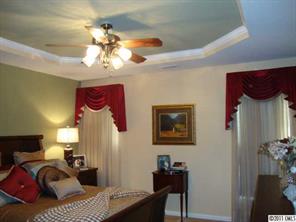 613 Colbert Way Fort Mill, SC 29715 - Photo 6 of 16 a bedroom with a bed and a chandelier