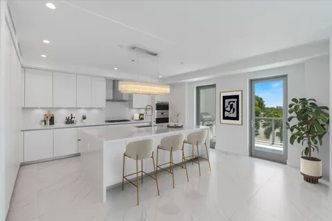 a kitchen with stainless steel appliances granite countertop a sink and a refrigerator