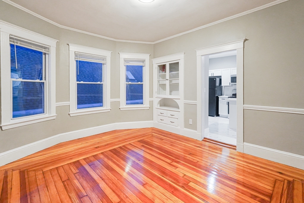 381 Adams Street, Unit 2 Boston, MA 02122 - Photo 16 of 42 a bedroom with a bed and wooden floor