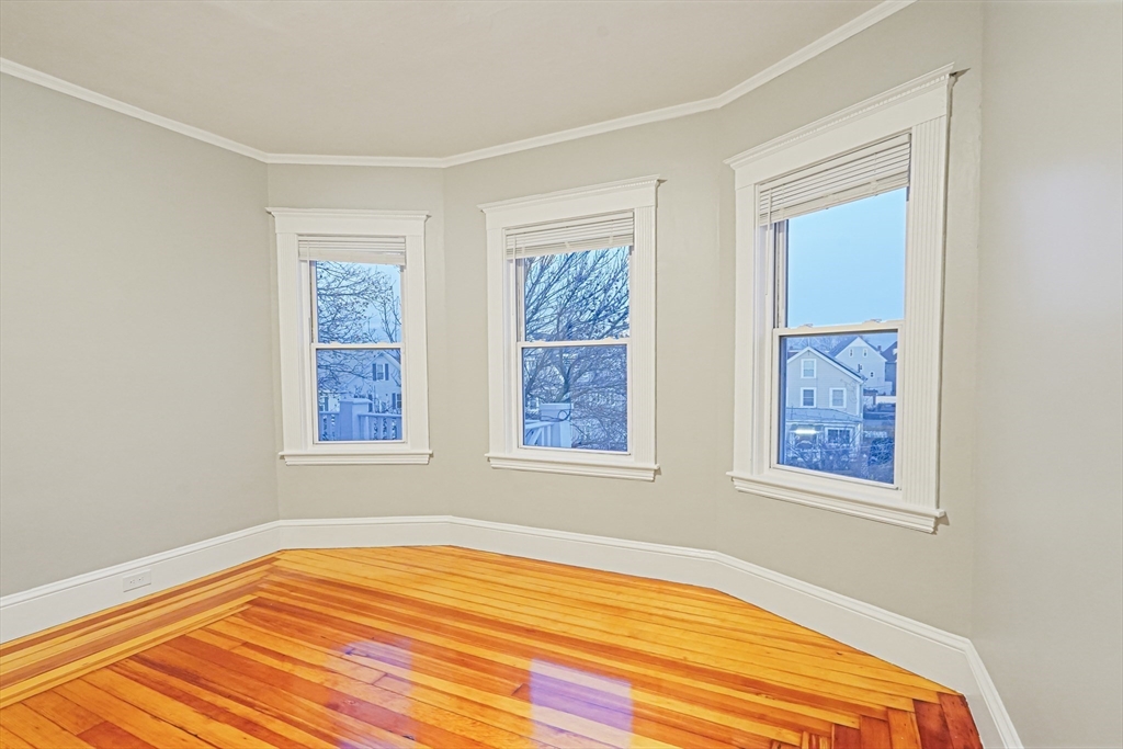 381 Adams Street, Unit 2 Boston, MA 02122 - Photo 24 of 42 a view of an empty room with wooden floor and a window