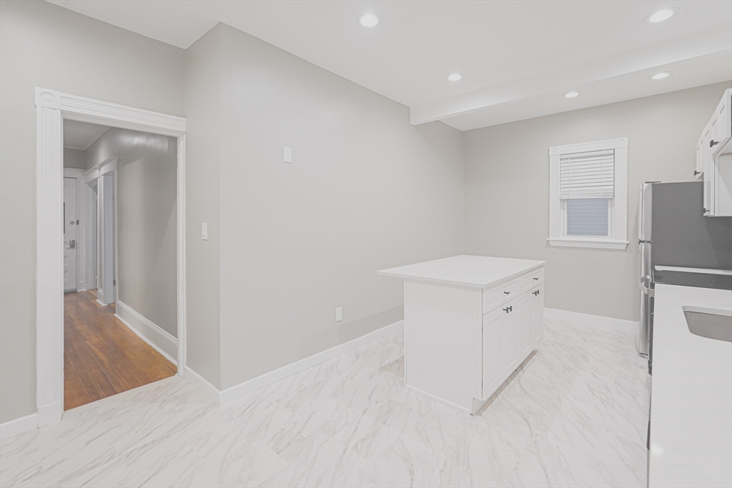 381 Adams Street, Unit 2 Boston, MA 02122 - Photo 4 of 42 a view of a kitchen with a sink and a refrigerator