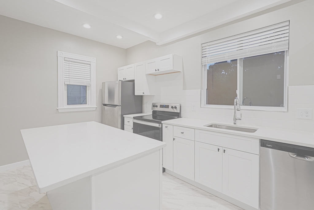 381 Adams Street, Unit 2 Boston, MA 02122 - Photo 5 of 42 a kitchen with a sink stove and refrigerator