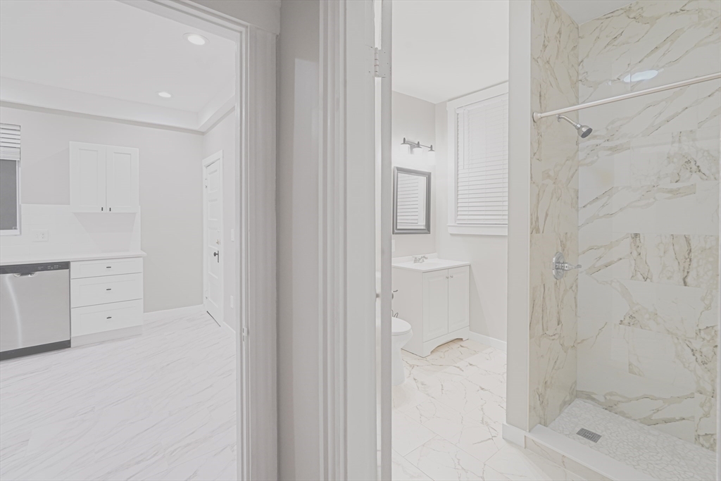 381 Adams Street, Unit 2 Boston, MA 02122 - Photo 8 of 42 a bathroom with a granite countertop shower a sink and a toilet