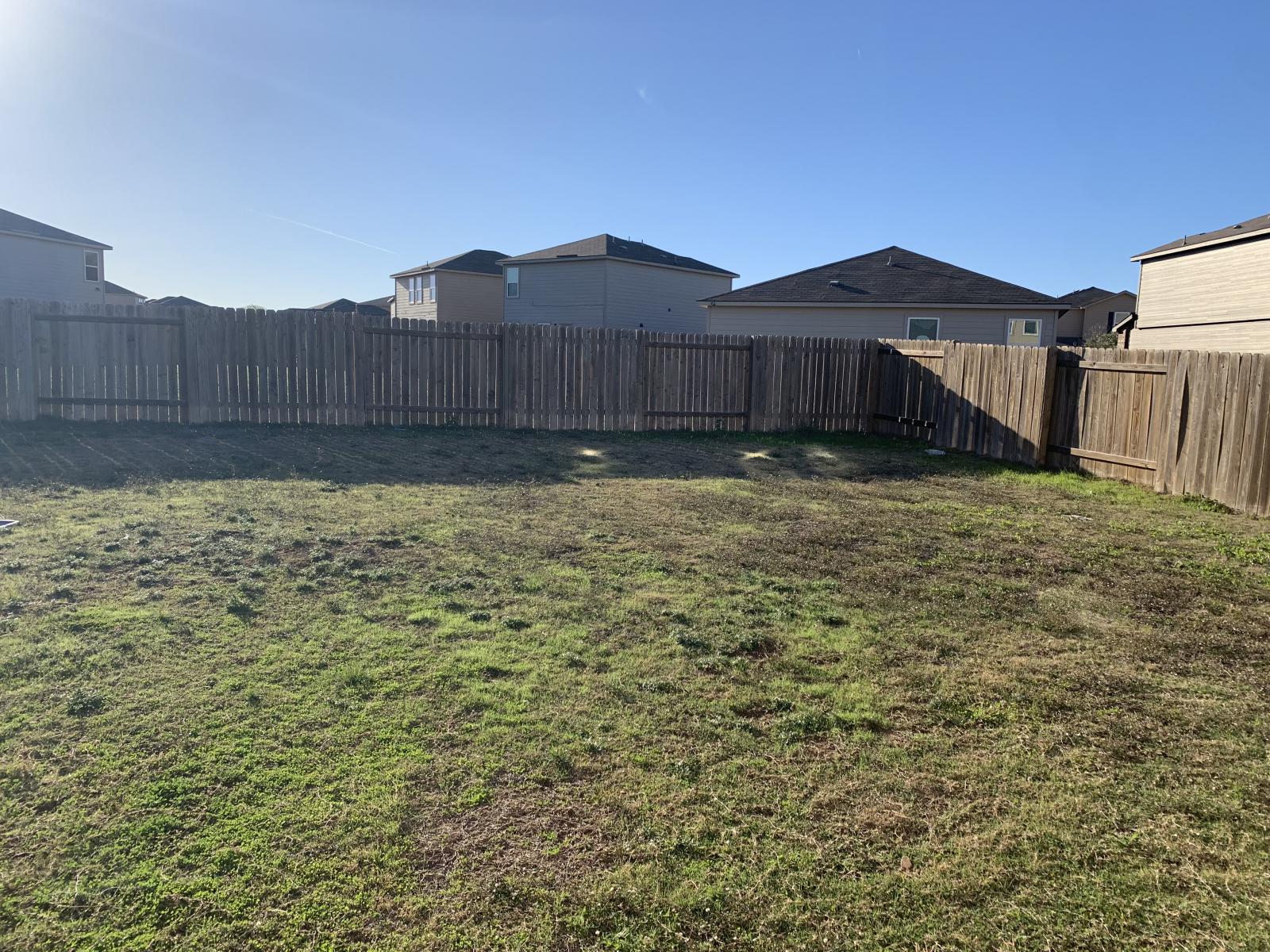 217 Denson Lane Jarrell, TX 76537 - Photo 8 of 26 Expansive backyard featuring a wood privacy fence and a grass lawn