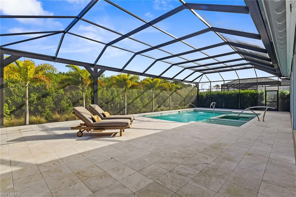 8829 Paradera Court Naples, FL 34112 - Photo 22 of 31 a view of a patio with a table and chairs under an umbrella
