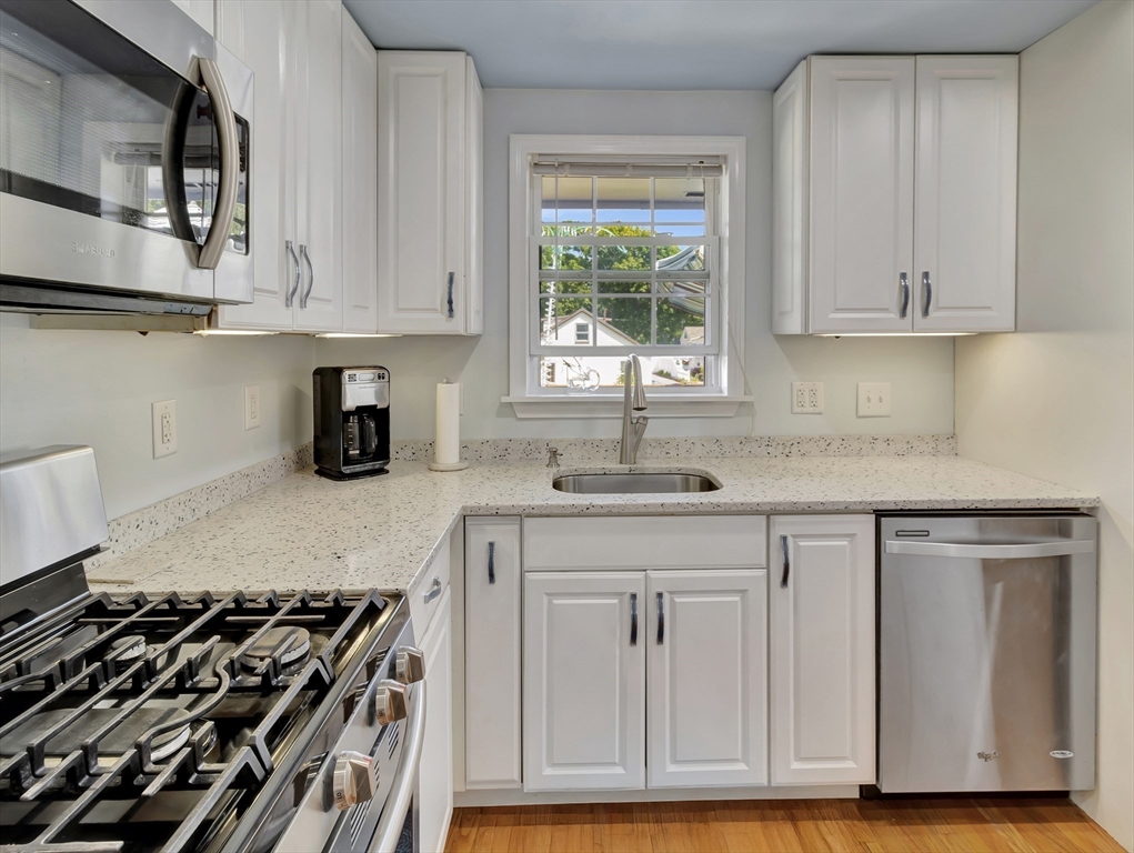 15 H Street Hull, MA 02045 - Photo 12 of 35 a kitchen with white cabinets and appliances