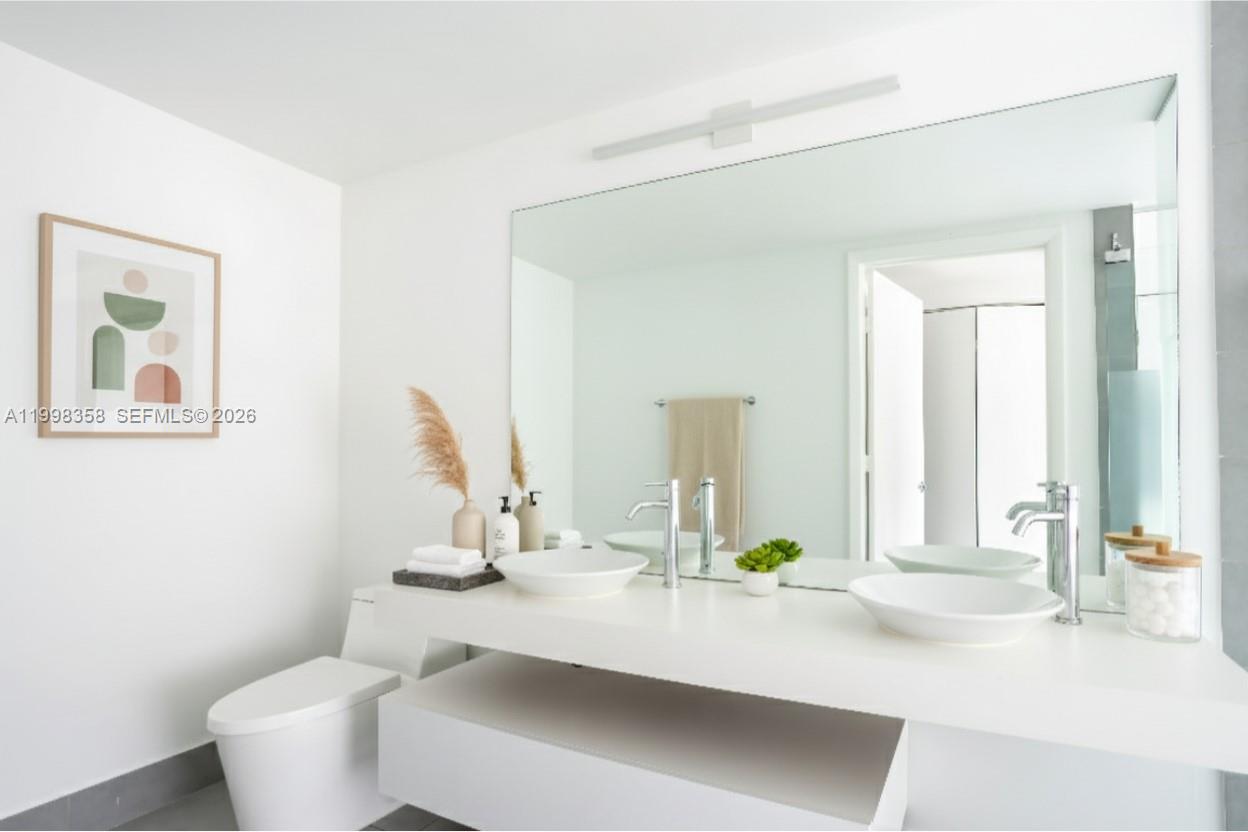 92 Southwest 3rd Street, Unit 3512 Miami, FL 33130 - Photo 11 of 67 a bathroom with a sink and a mirror with toilet