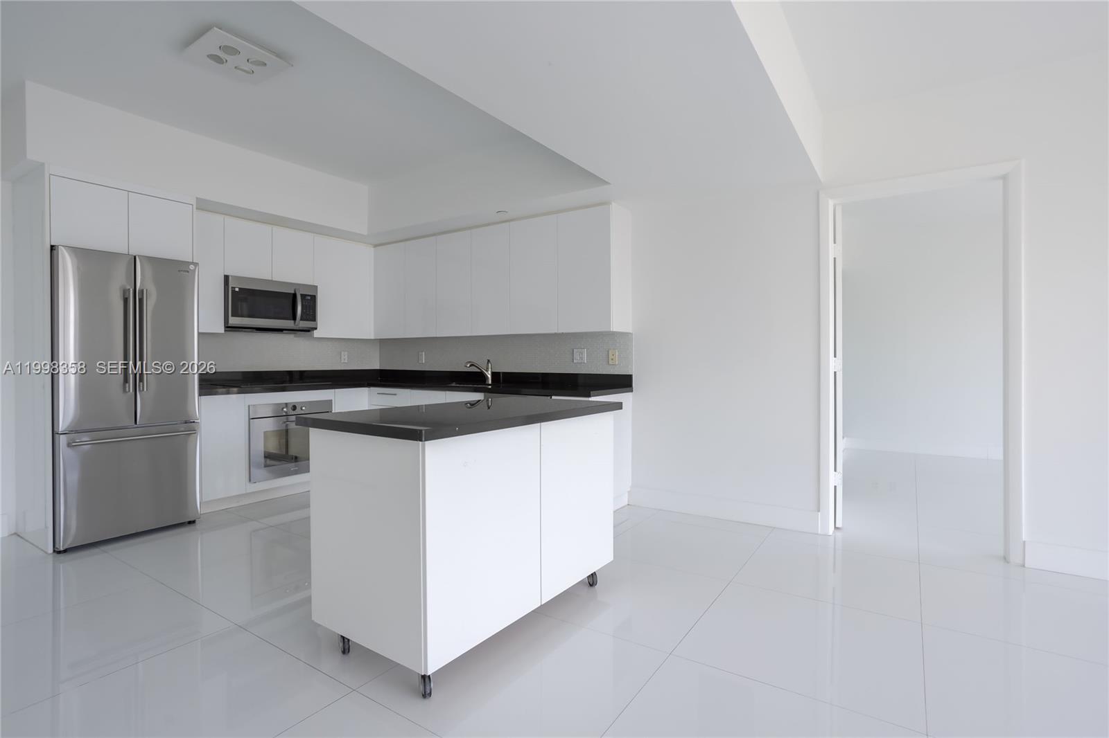 92 Southwest 3rd Street, Unit 3512 Miami, FL 33130 - Photo 6 of 67 a kitchen with granite countertop white cabinets and stainless steel appliances