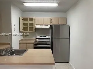 a kitchen with a refrigerator and a sink