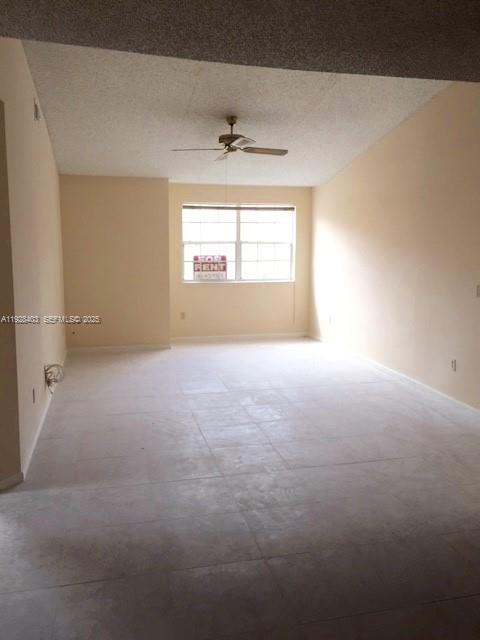 18324 Northwest 68th Avenue, Unit H Hialeah, FL 33015 - Photo 7 of 13 en empty room with windows and ceiling fan