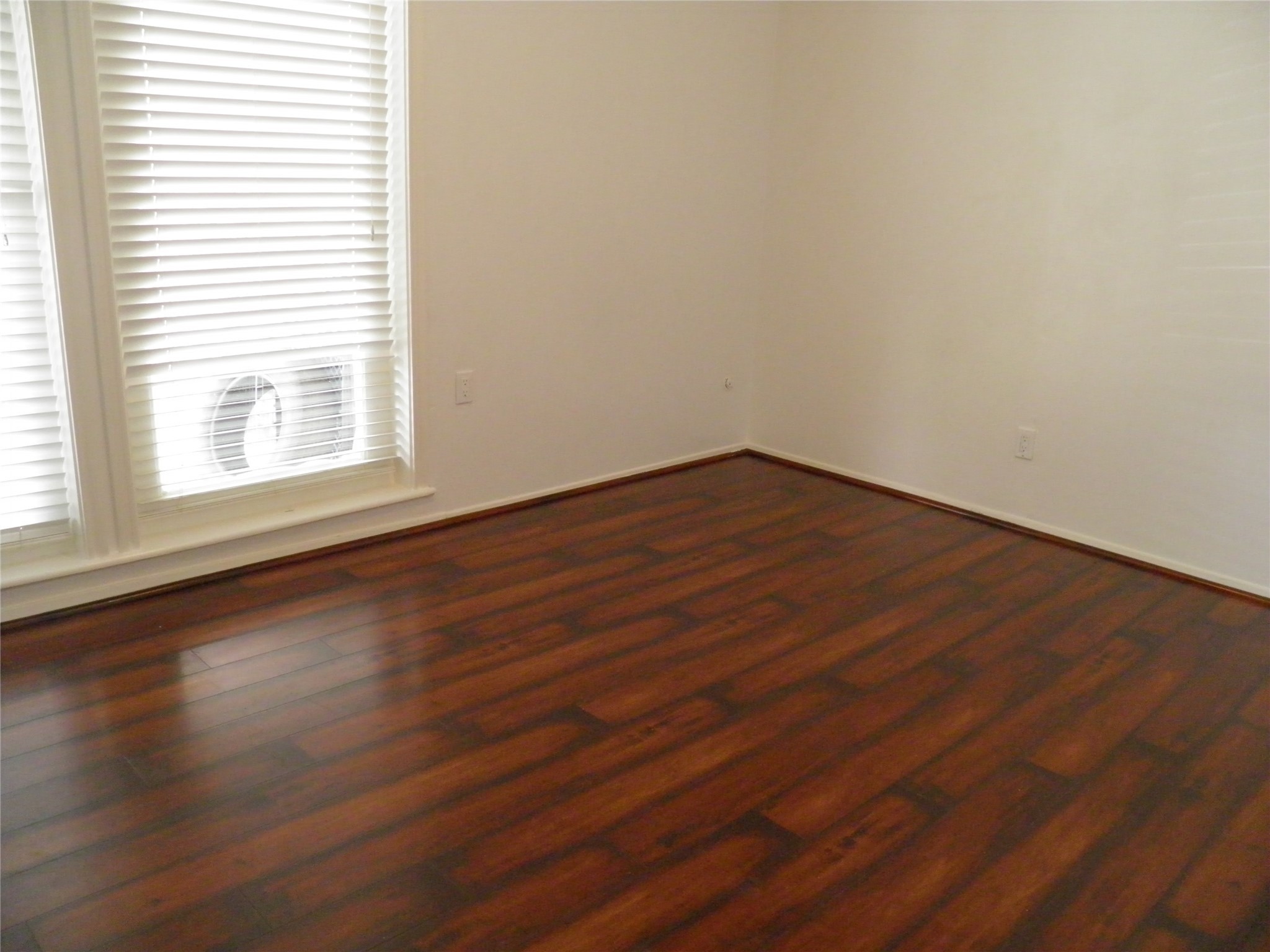 8827 Neff Street Houston, TX 77036 - Photo 4 of 12 an empty room with wooden floor and windows