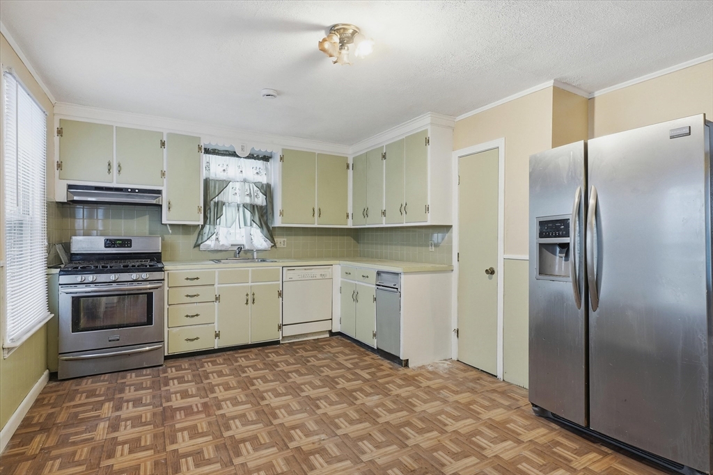 494 Fletcher Street Lowell, MA 01854 - Photo 6 of 29 a kitchen with stainless steel appliances a refrigerator sink and stove