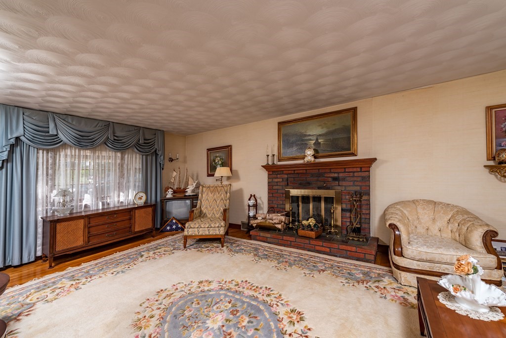 46 Pilgrim Road Braintree, MA 02184 - Photo 24 of 35 a living room with furniture a fireplace and a flat screen tv