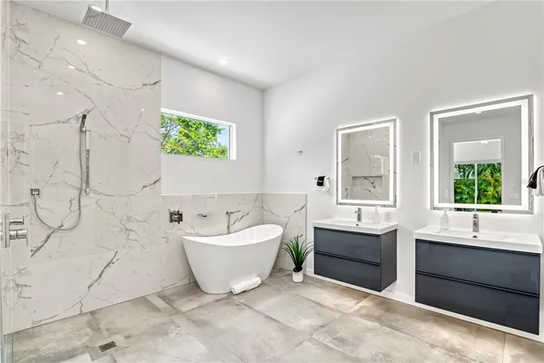 a bathroom with a white tub a vanity and a shower