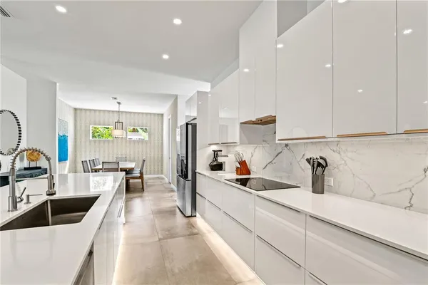 a large kitchen with kitchen island a counter space a sink a window and stainless steel appliances
