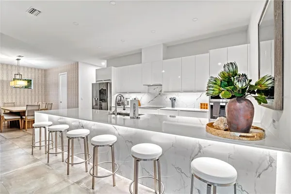 a kitchen with a sink white cabinets and stainless steel appliances