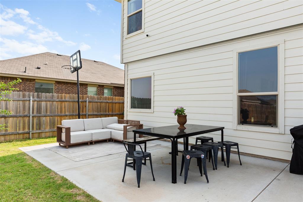 3105 Marston Road Lorena, TX 76655 - Photo 35 of 40 Private concrete patio featuring a white siding exterior, a wood privacy fence, and a grass lawn