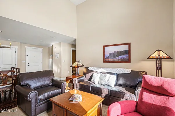 a kitchen with stainless steel appliances granite countertop a dining table chairs stove and white cabinets