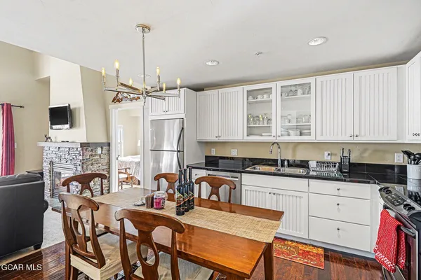 a kitchen with granite countertop a stove a sink and a refrigerator