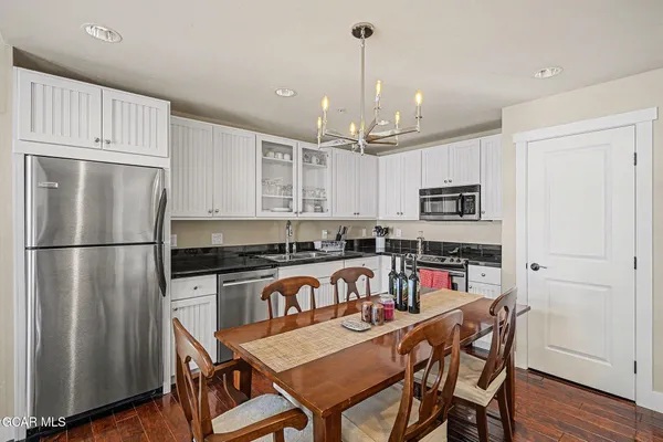 a kitchen with stainless steel appliances granite countertop a refrigerator a stove and a wooden floors