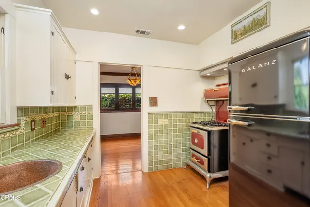 a kitchen with stainless steel appliances granite countertop a refrigerator a stove and a sink