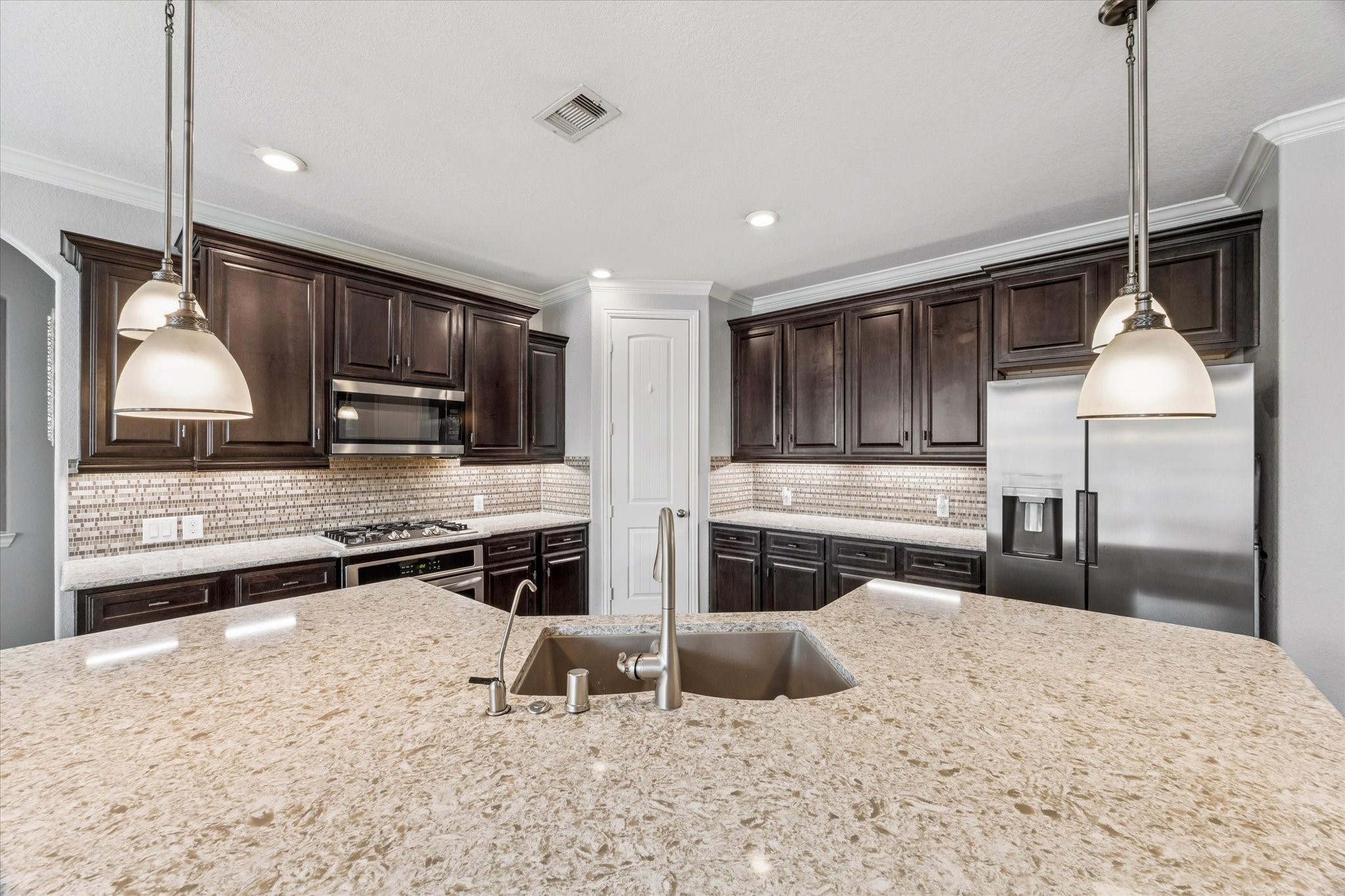 2283 Rising Bay Court League City, TX 77573 - Photo 15 of 45 a kitchen with stainless steel appliances kitchen island granite countertop a stove and a refrigerator
