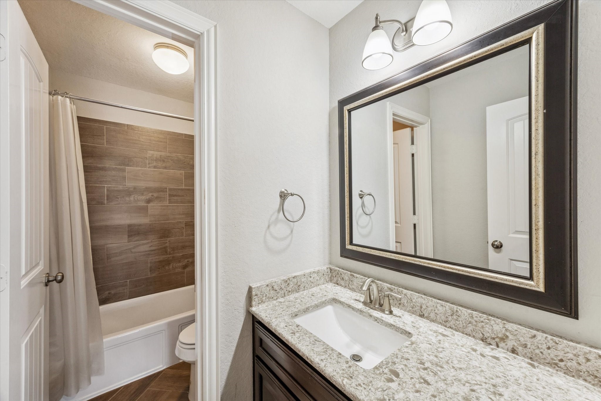 2283 Rising Bay Court League City, TX 77573 - Photo 34 of 45 a bathroom with a granite countertop sink a mirror and a bathtub