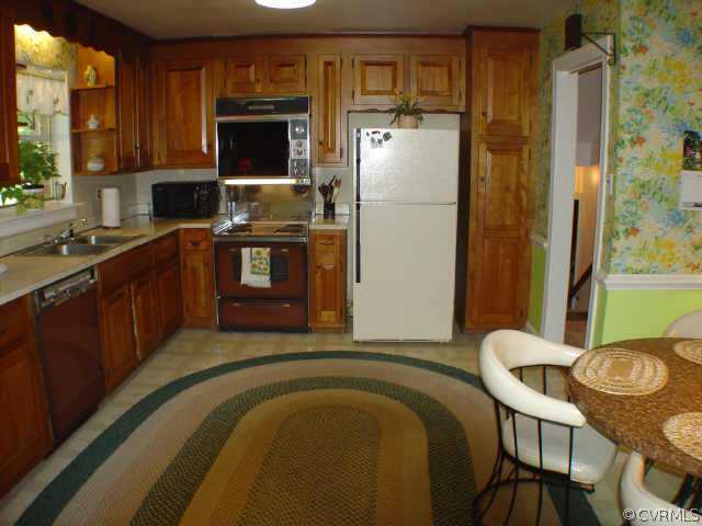 13361 Kingsmill Road Midlothian, VA 23113 - Photo 5 of 8 a kitchen with stainless steel appliances granite countertop a refrigerator a stove and a sink with wooden cabinets