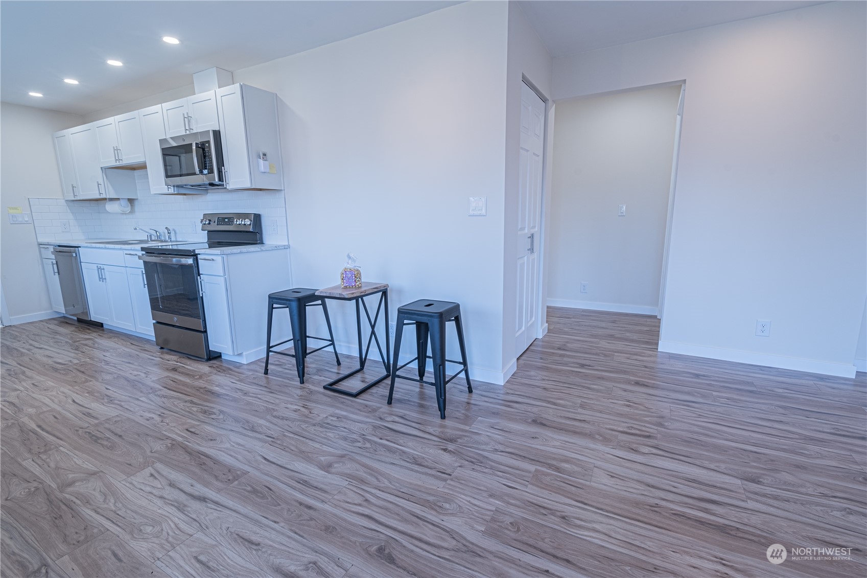 1125 Southwest 356th Street Federal Way, WA 98023 - Photo 8 of 27 a kitchen with stainless steel appliances granite countertop a stove top oven a sink and white cabinets with wooden floor