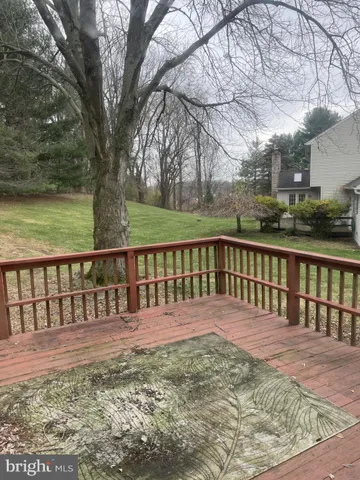 a view of swimming pool with lawn chairs and large trees