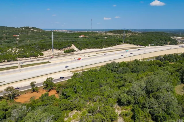 a view of a lake with a yard and large trees
