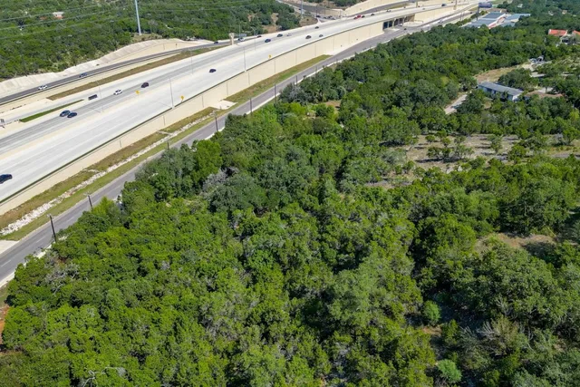 a view of a green field with trees in the background