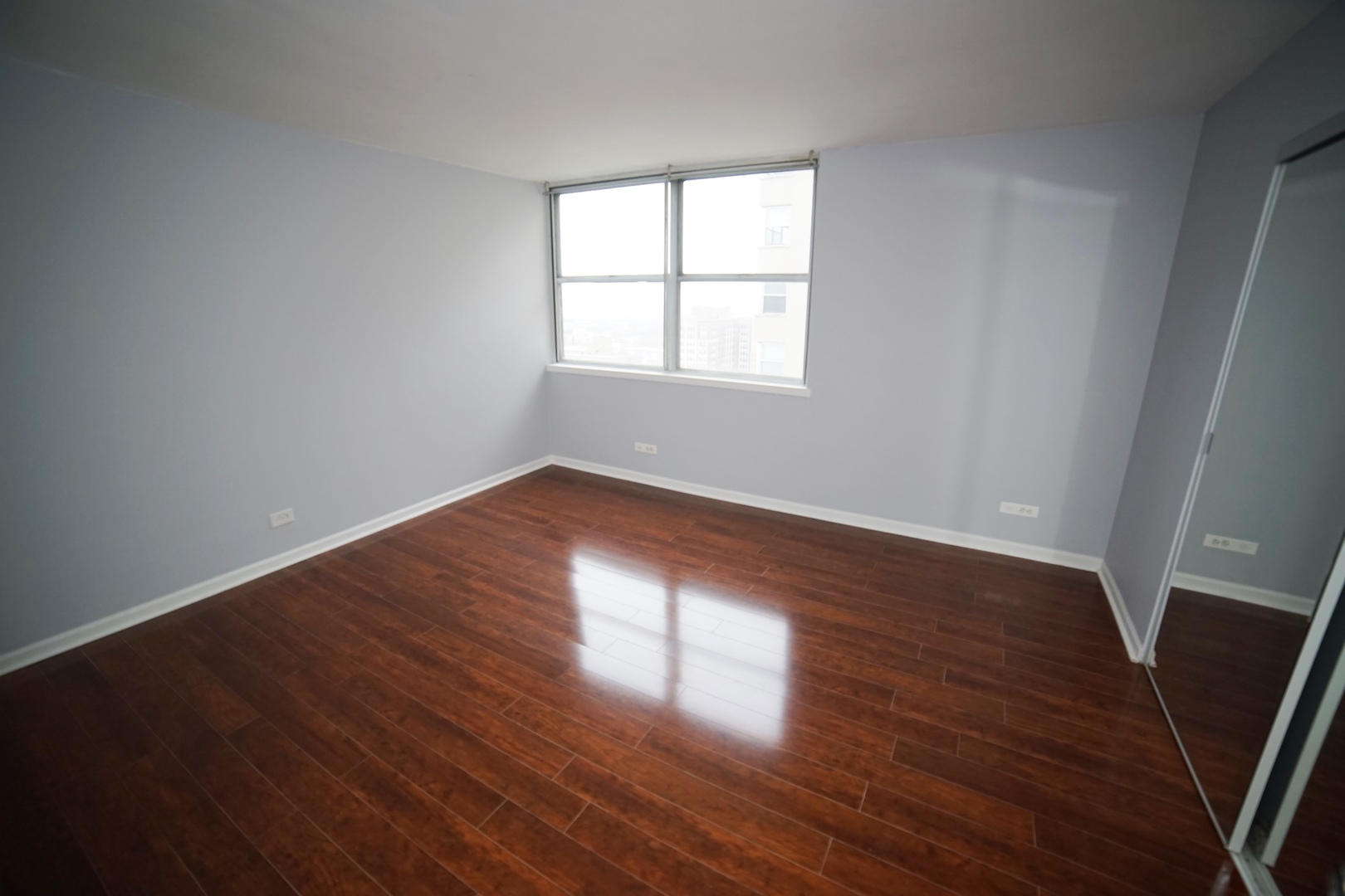 6301 North Sheridan Road, Unit 23V Chicago, IL 60660 - Photo 17 of 22 an empty room with wooden floor and windows