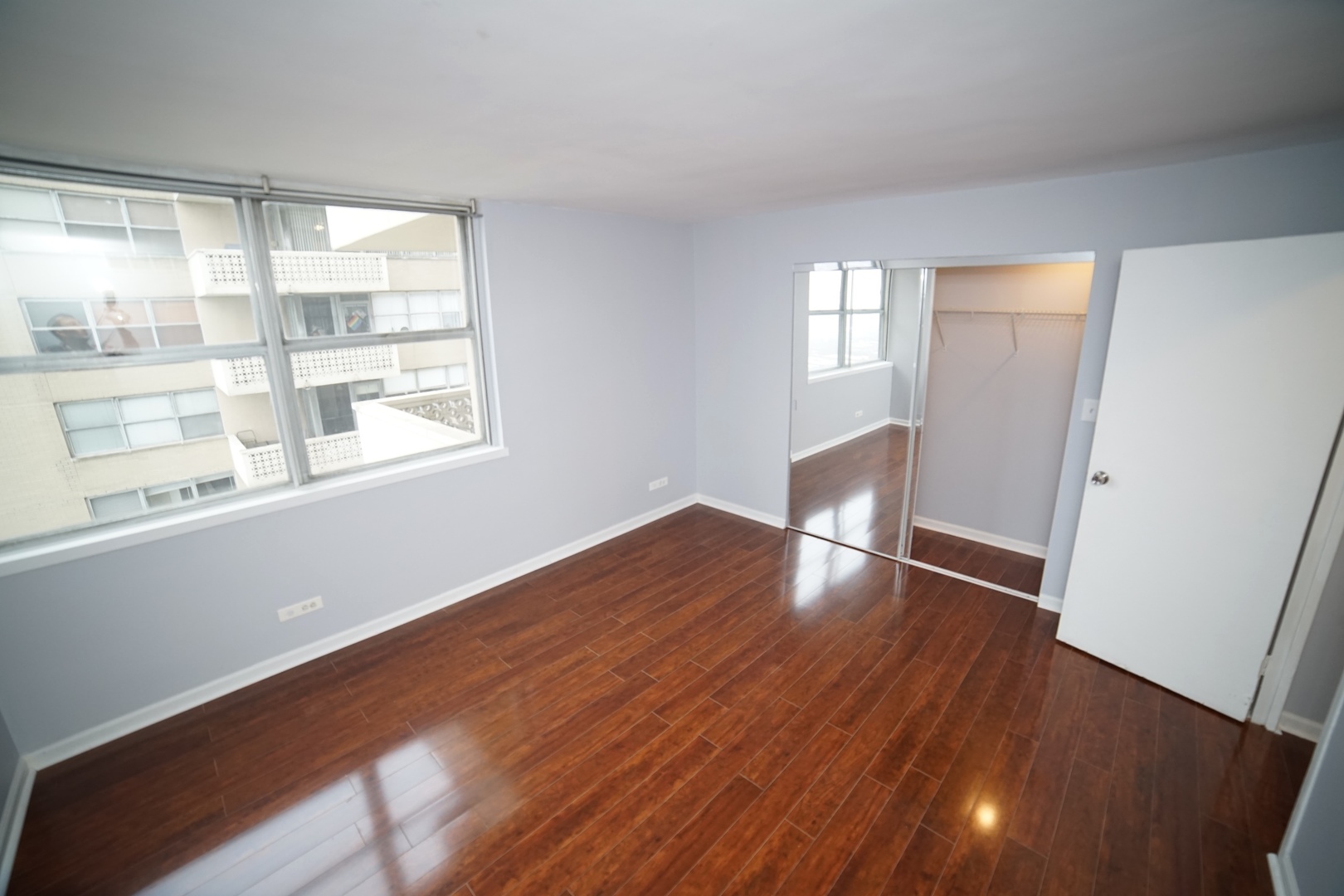 6301 North Sheridan Road, Unit 23V Chicago, IL 60660 - Photo 18 of 22 a view of an empty room with wooden floor and a window
