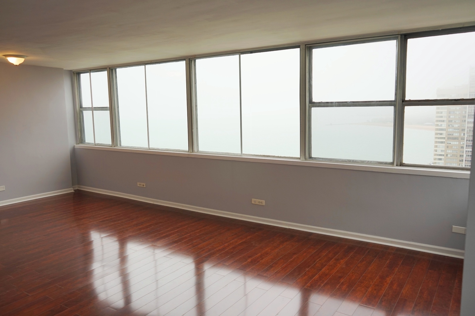 6301 North Sheridan Road, Unit 23V Chicago, IL 60660 - Photo 6 of 22 an empty room with wooden floor and windows