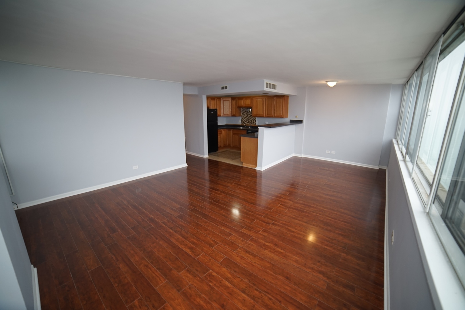6301 North Sheridan Road, Unit 23V Chicago, IL 60660 - Photo 7 of 22 wooden floor in an empty room with a window
