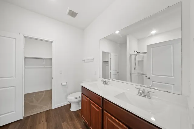 a bathroom with a sink a toilet and shower