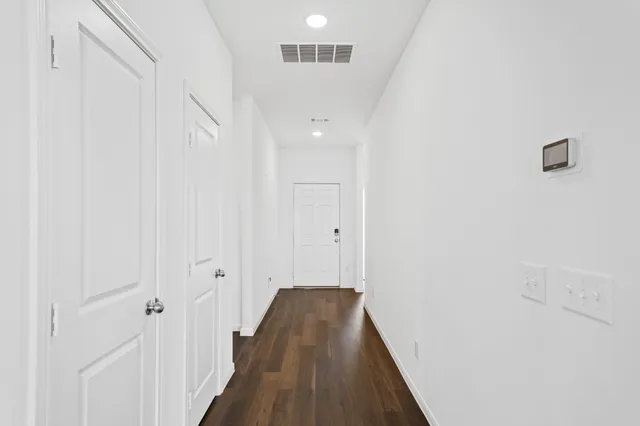 a view of a hallway with wooden floor
