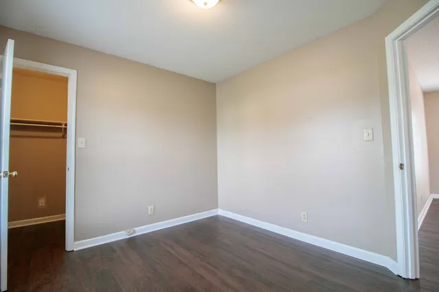 an empty room with wooden floor and closet