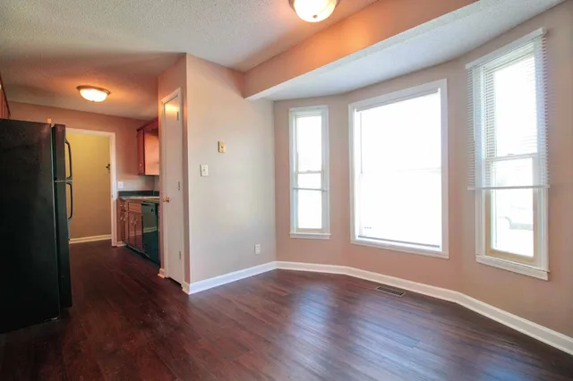 a view of a kitchen with wooden floor and a refrigerator