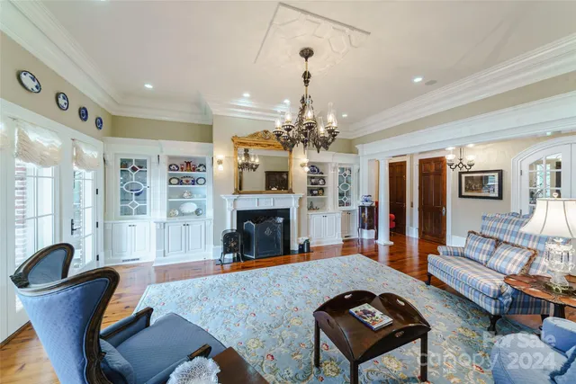a living room with furniture a chandelier and a fireplace