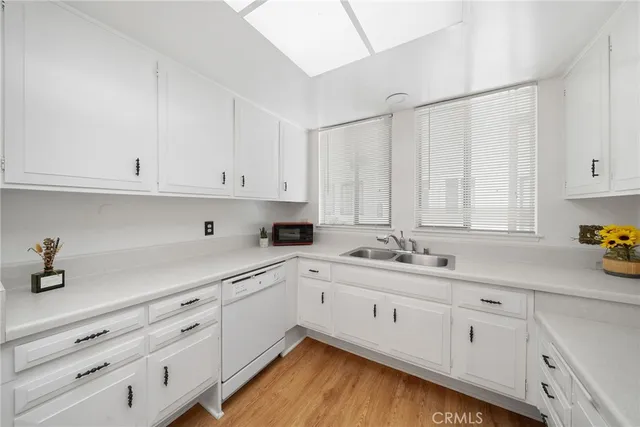 a kitchen with white cabinets and refrigerator