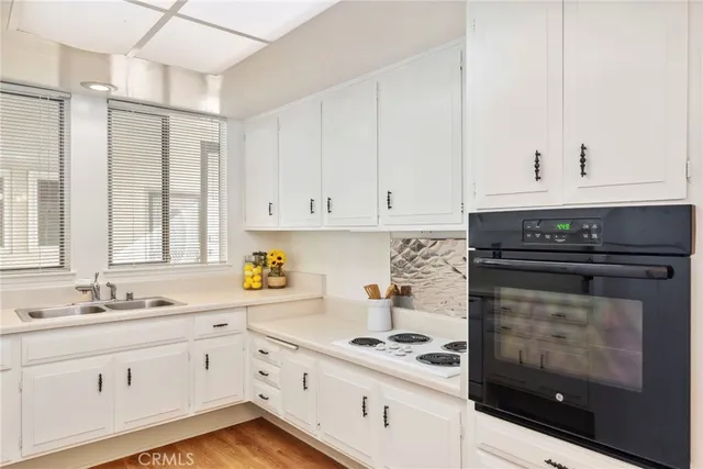 a kitchen with white cabinets and white appliances